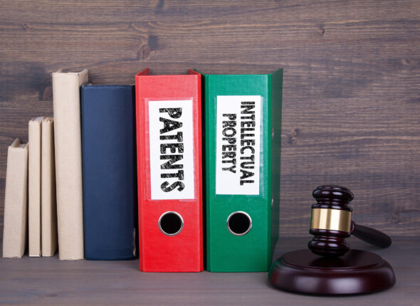 Patents and Intellectual Property. Wooden gavel and books in bac