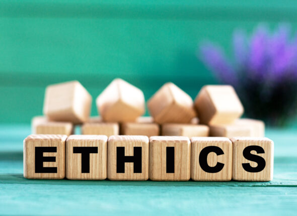 ETHICS - word on wooden cubes on a green background with lavender