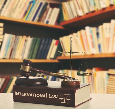 Wooden gavel with justice scales on table in library