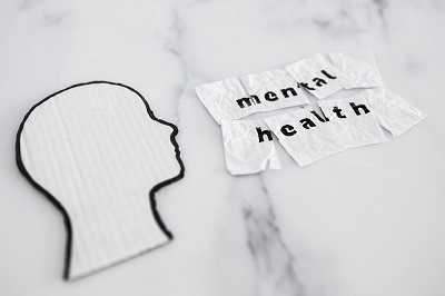 mental health concept, cardboard head next to scrunched up torn