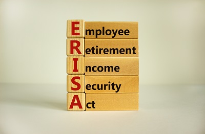 Wooden blocks and cubes with words 'ERISA - employee retirement income security act'. Beautiful white background. Copy space. Business concept.