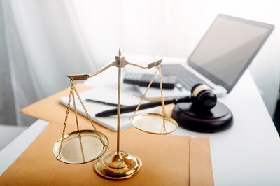 Business and lawyers discussing contract papers with brass scale