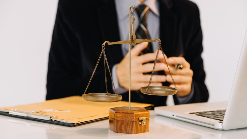 Business and lawyers discussing contract papers with brass scale