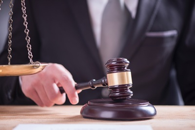 Close up of Male lawyer or judge hand's striking the gavel on so