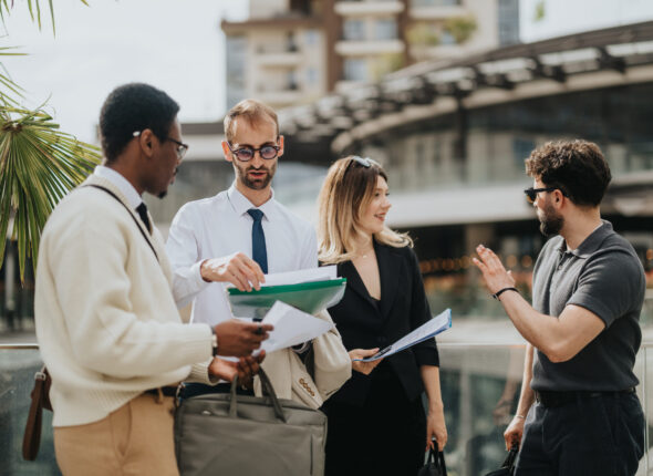 Group of professionals collaborating outdoors at a modern business setting
